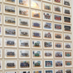 A collection of school class photos pinned up on a wall.